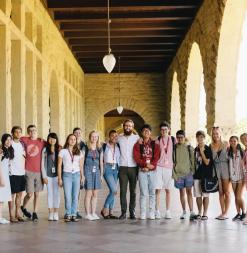 A group of participants stands in Stanford's famous Main Quad arches.