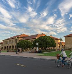 Two people bike past the Main Quad.