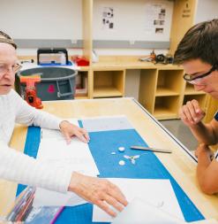 A participant works with the instructor to review drawings for a prototype.