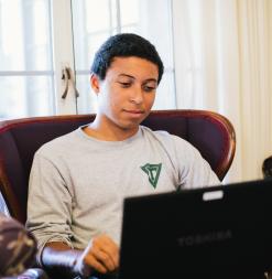 In a common area, a participant uses a laptop during the program.