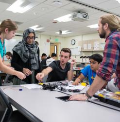 A group o participants and instructors from Stanford Online High School, work together on campus in the summer.