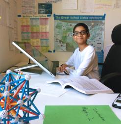 At his desk, a student prepares for classes at Stanford Online High School.