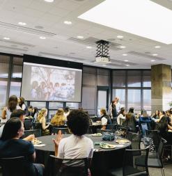 A group of Stanford AI4ALL alumnae enjoy a banquet and watch a slideshow of the past few years of the program.