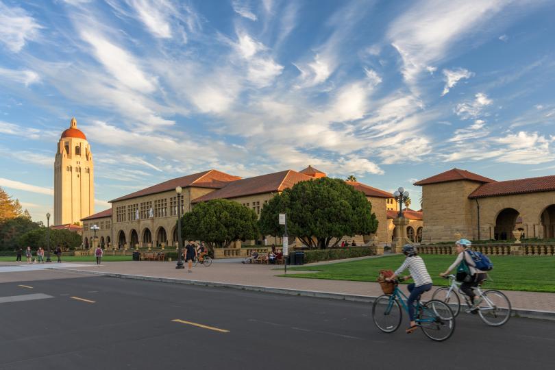 Two people bike past the Main Quad.